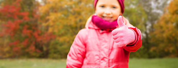 Image showing happy girl showing thumbs up over autumn park