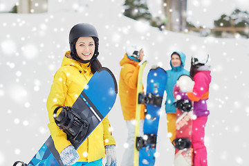 Image showing happy friends in helmets with snowboards