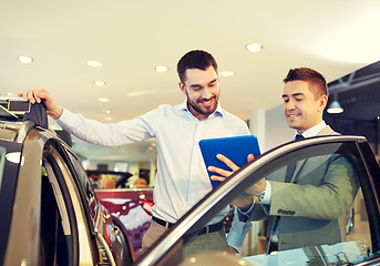 Image showing happy man with car dealer in auto show or salon