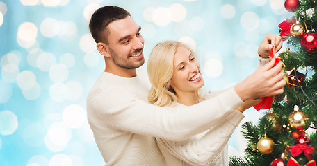 Image showing happy couple decorating christmas tree at home