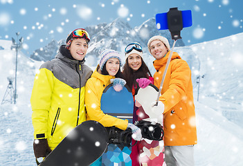 Image showing happy friends with snowboards and smartphone