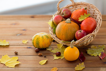 Image showing close up of pumpkins in basket on wooden table