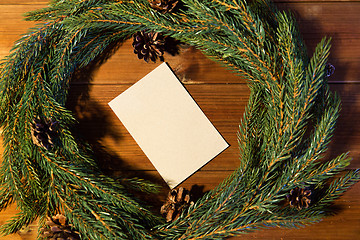 Image showing natural green fir wreath with note on wooden board