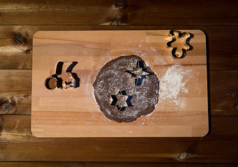 Image showing close up of ginger dough, molds and flour on board