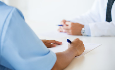 Image showing close up of doctor taking notes at hospital