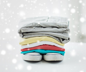 Image showing close up of folded shirts and boots on table