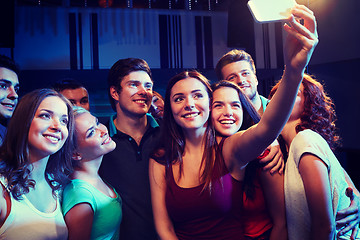 Image showing friends with smartphone taking selfie in club