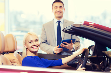 Image showing happy woman with car dealer in auto show or salon