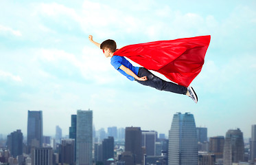 Image showing boy in red superhero cape and mask flying on air