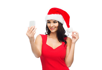 Image showing woman in santa hat taking selfie by smartphone