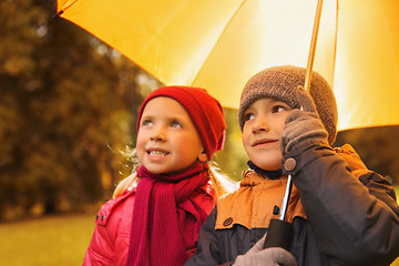 Image showing happy boy and girl with umbrella in autumn park