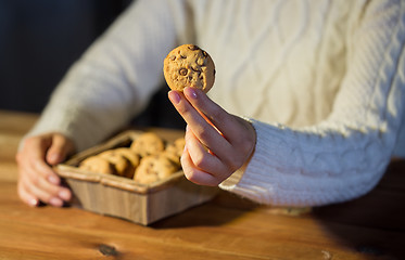 Image showing close up of woman with oat cookies at home