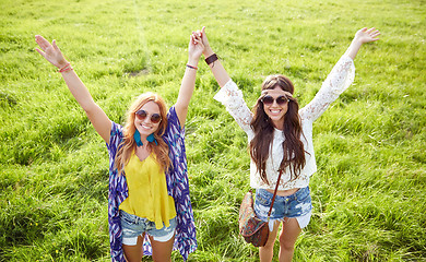 Image showing smiling young hippie women dancing on green field