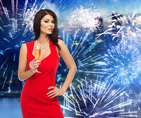 Image showing beautiful woman with champagne glass over firework