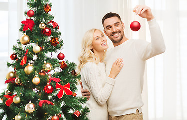 Image showing happy couple decorating christmas tree at home