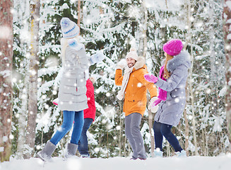 Image showing group of happy friends playing snowballs in forest