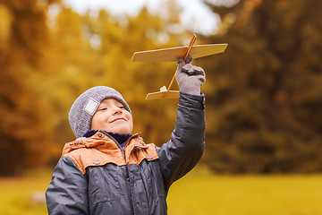 Image showing happy little boy playing with toy plane outdoors