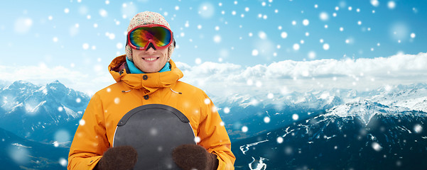 Image showing happy young man in ski goggles over mountains