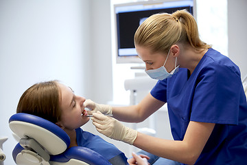 Image showing female dentist checking patient girl teeth