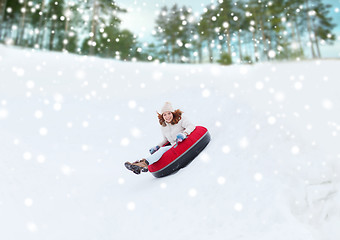 Image showing happy teenage girl sliding down on snow tube