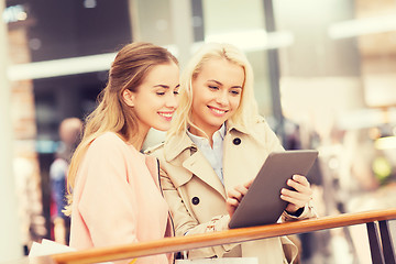 Image showing happy young women with tablet pc and shopping bags