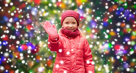 Image showing happy little girl waving hand over christmas snow