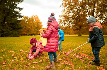 Image showing group of children collecting leaves in autumn park