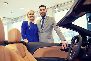 Image showing happy couple buying car in auto show or salon