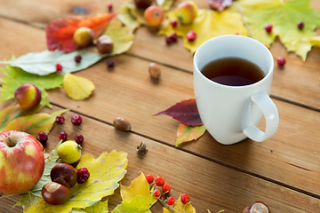 Image showing close up of tea cup on table with autumn leaves