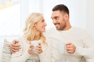 Image showing happy couple with cups drinking tea at home