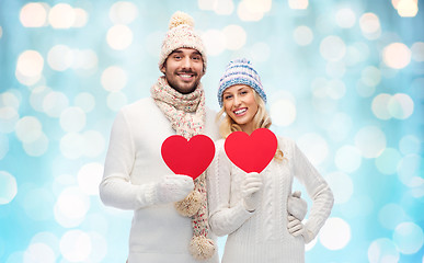 Image showing smiling couple in winter clothes with red hearts