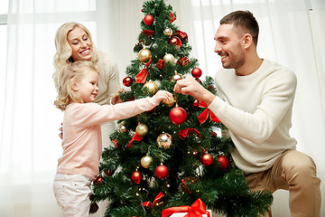 Image showing happy family decorating christmas tree at home