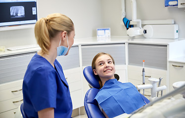 Image showing happy female dentist with patient girl at clinic