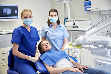 Image showing happy female dentist with patient girl at clinic