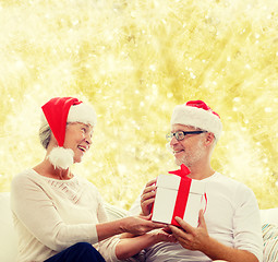 Image showing happy senior couple with gift box at home