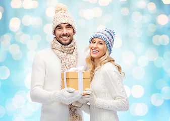 Image showing smiling couple in winter clothes with gift box