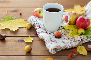 Image showing close up of tea cup on table with autumn leaves