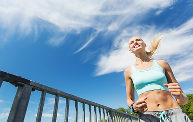 Image showing smiling young woman running outdoors