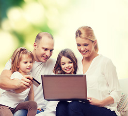 Image showing happy family with laptop computer and credit card