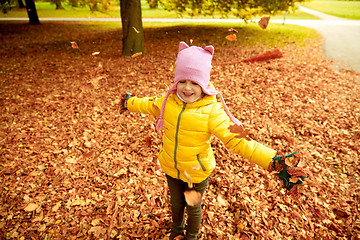 Image showing happy girl playing with autumn leaves in park