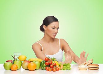 Image showing woman with fruits rejecting hamburger