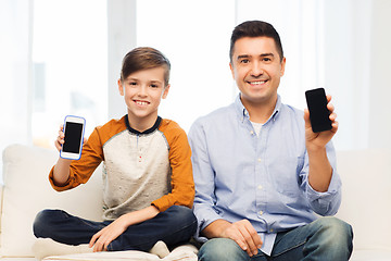 Image showing happy father and son with smartphones at home