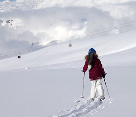 Image showing Girl on skis in off-piste slope with new fallen snow at sun day