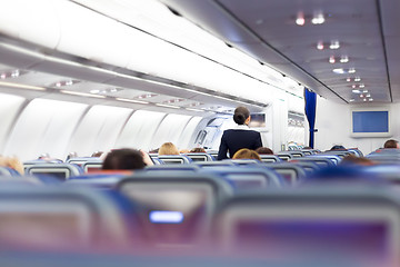 Image showing Interior of airplane with passengers on seats.