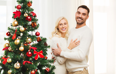 Image showing happy couple hugging near christmas tree at home