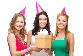 Image showing three smiling women in blue hats with gift box