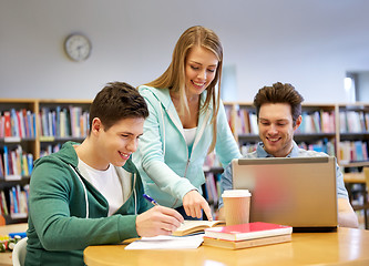 Image showing happy students with laptop and books at library