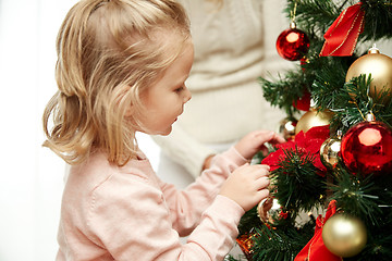 Image showing little girl decorating christmas tree at home