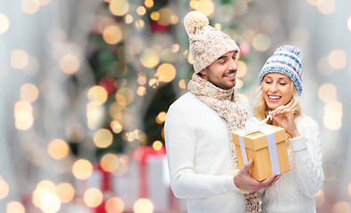 Image showing smiling couple in winter clothes with gift box