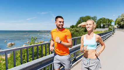 Image showing smiling couple running at summer seaside